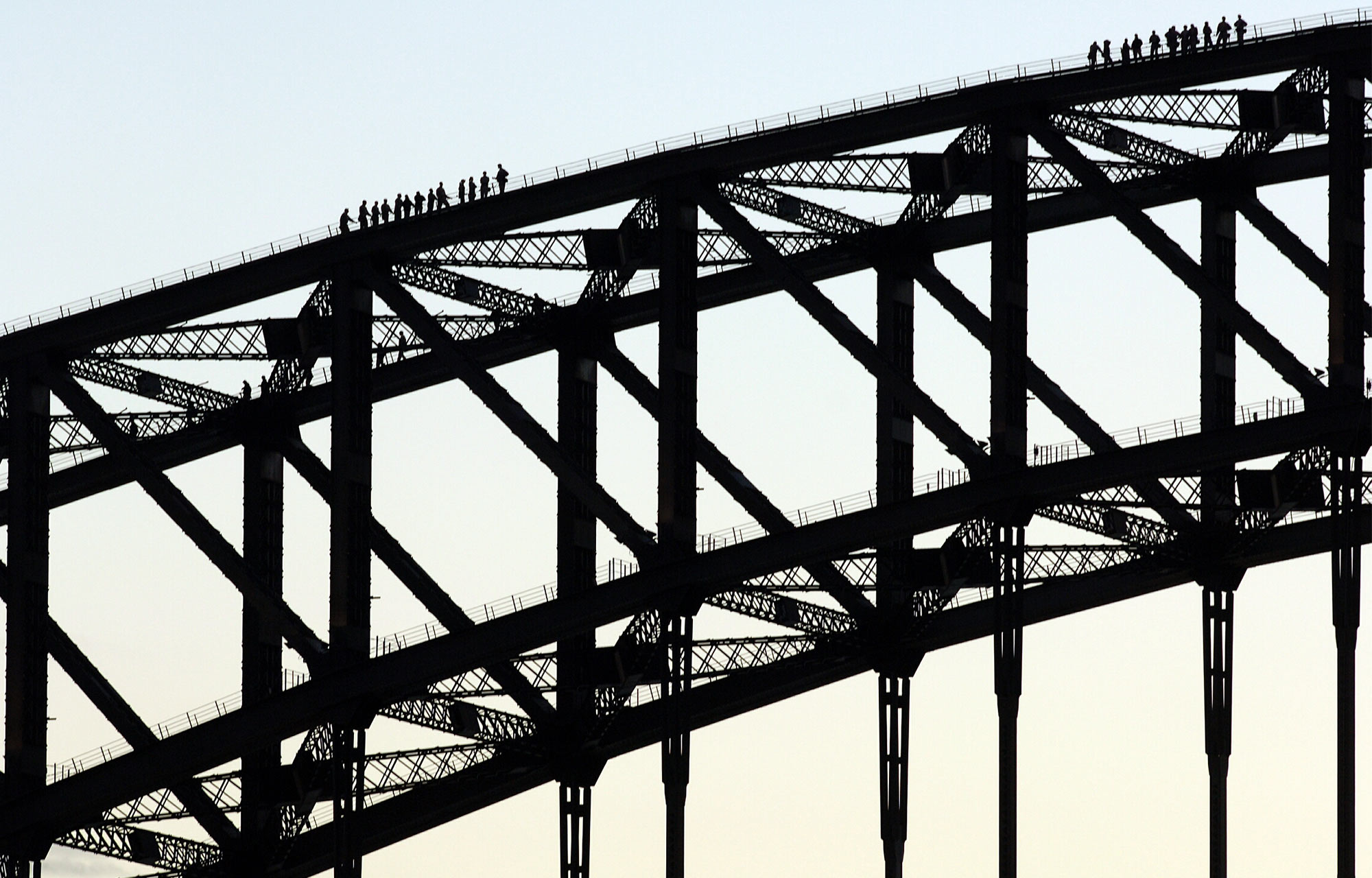 one section of the Sydney Harbour Bridge famous arches with tiny climbers along the top
