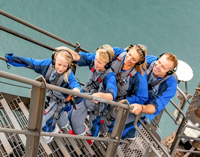 family of four climbing stairs on the sydney harbour bridge on the summit insider bridgeclimb experience