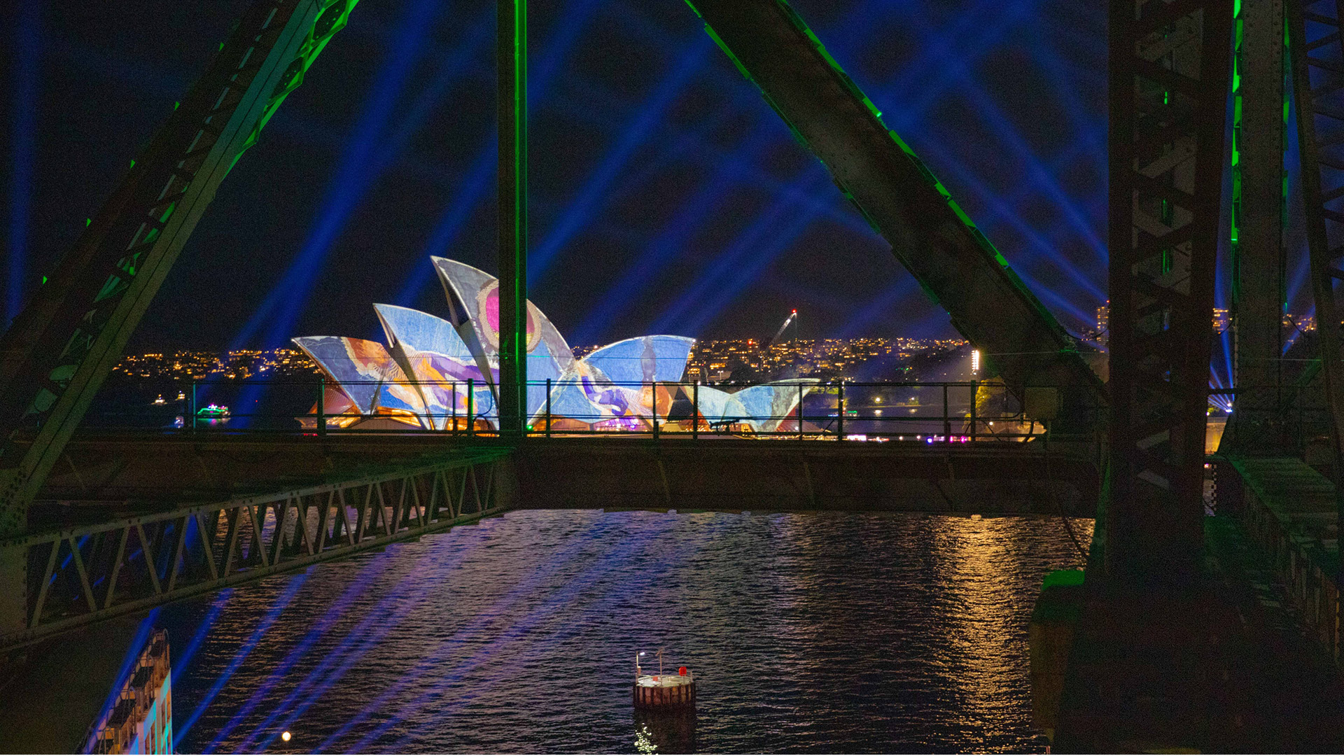 view of the sydney opera house lit up during Vivid Sydney from the harbour bridge