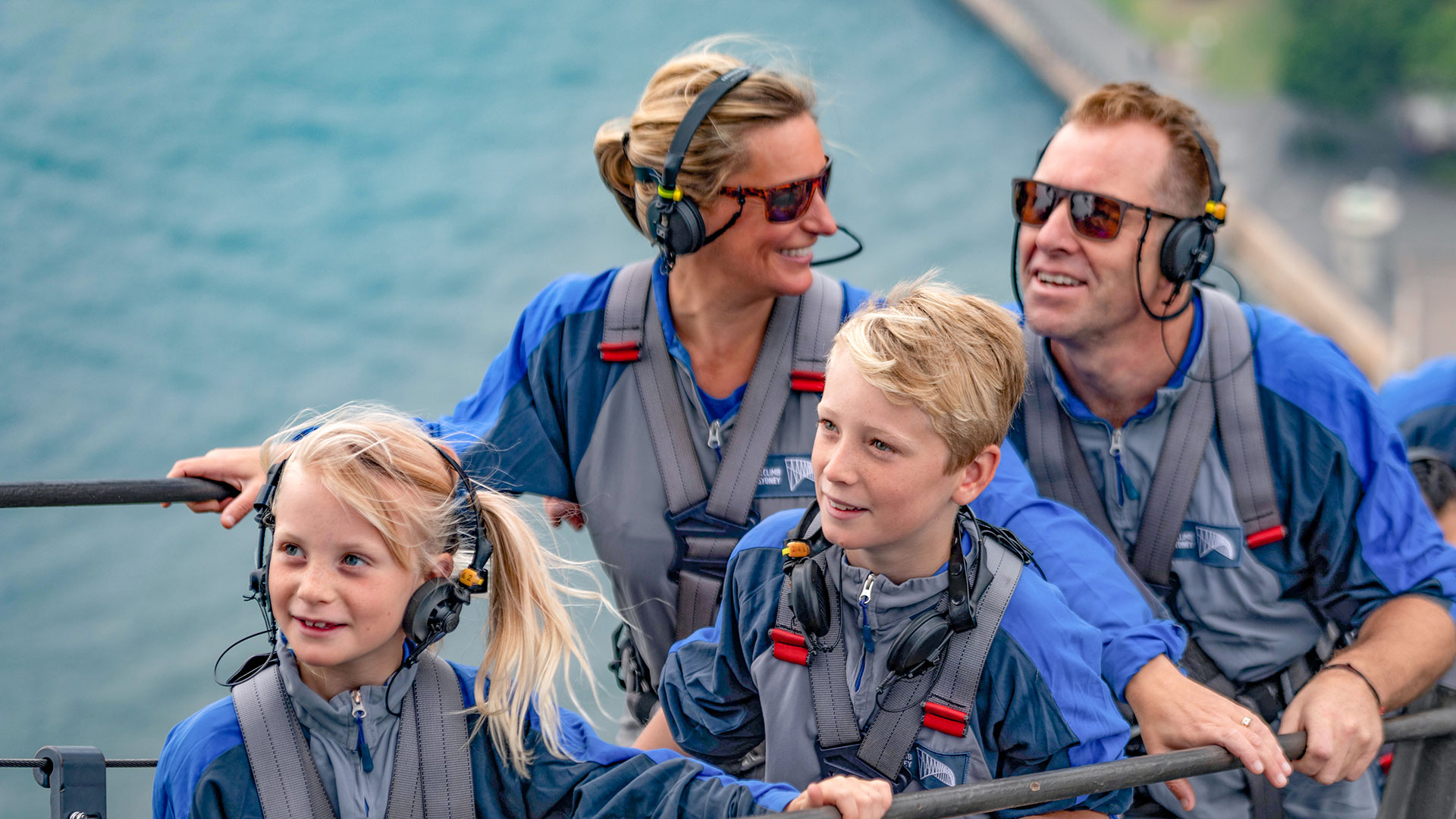 a family of four - mum, dad, son and daughter climb the sydney harbour bridge