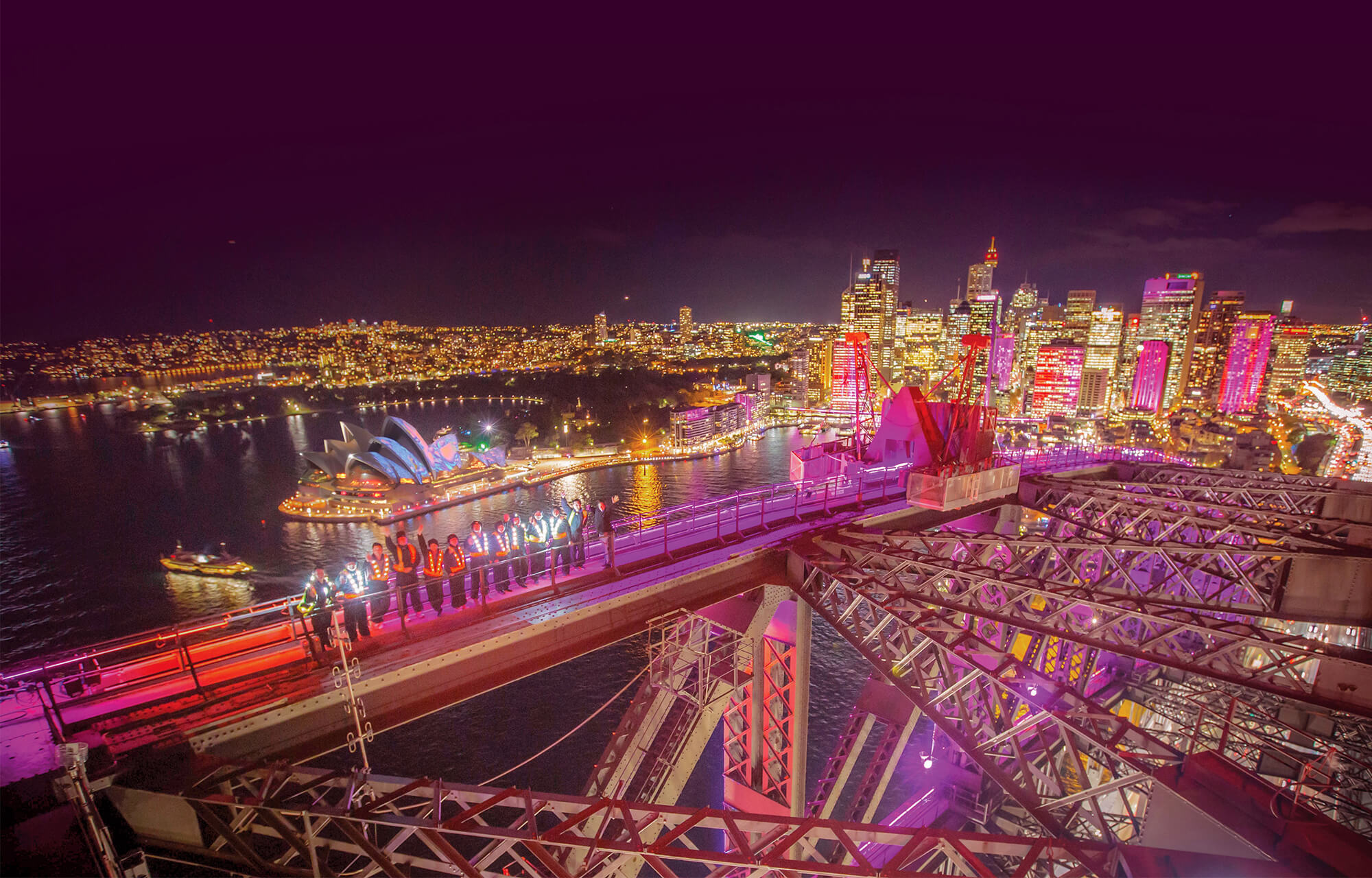 group of people climbing the sydney harbour bridge to see vivid